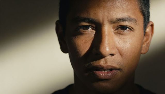 Closeup portrait thoughtful young man in dramatic side light showing skin texture and shadow