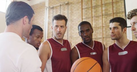 Basketball Coach Instructing Determined Athletes on Court