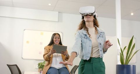 Diverse colleagues engaging with virtual reality in office environment