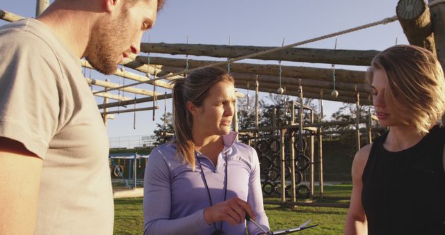 Fitness Trainer Discussing Exercise Plan with Clients Outdoors - Download Free Stock Images Pikwizard.com