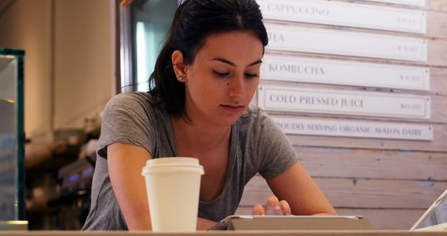 Young Woman Working on Tablet in Coffee Shop - Download Free Stock Images Pikwizard.com