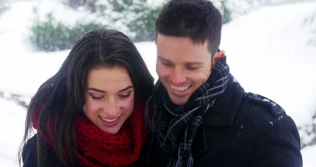 Smiling couple taking selfie on mobile phone during winter