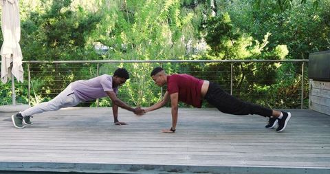 Friends Performing Plank Handshake Push-Ups for Outdoor Fitness