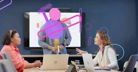 Collaborating team presenting data in boardroom with laptops, charts and analytics