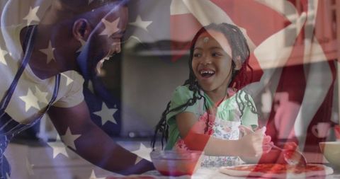 Father and daughter cooking together with flag overlay