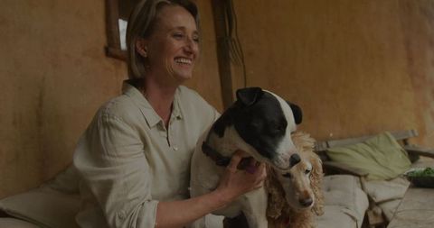 Smiling Woman Enjoying Relaxation with Dogs in Rustic Outdoor Setting