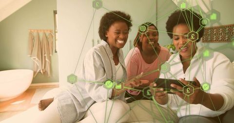 Three friends sharing tablet in cozy loft bedroom with digital finance network overlay