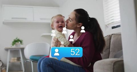 Mother Kissing Baby Displaying Social Media Engagement