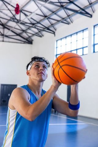 Male Basketball Athlete Focused on Shooting Indoors