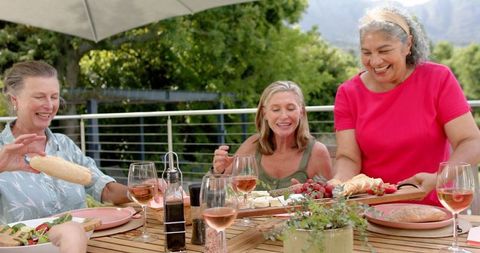 Diverse Senior Friends Celebrating Meal Outdoors