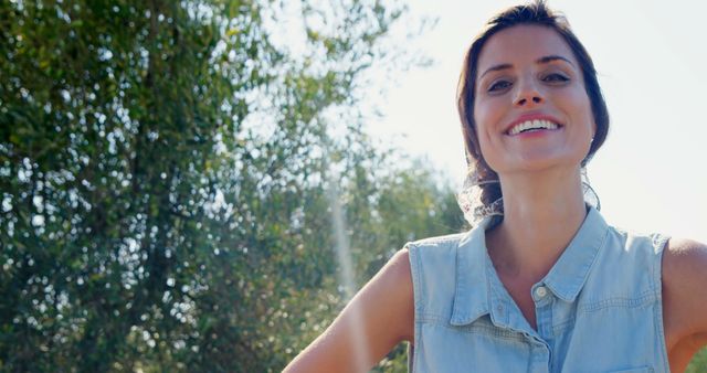 Smiling Woman Outdoors on Sunny Day with Trees in Background - Download Free Stock Images Pikwizard.com