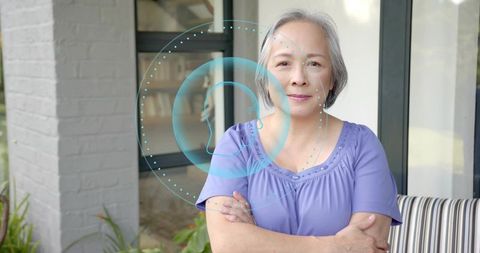 Senior Asian Woman Standing on Porch Crossing Arms Showing AR Head Silhouette Overlay