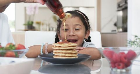 Cheerful Young Girl Enjoying Homemade Pancake Breakfast