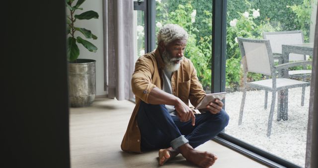 Senior Man with Tablet Relaxing at Home by Window - Download Free Stock Images Pikwizard.com