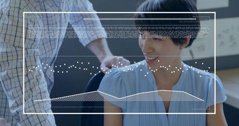 Smiling Asian woman collaborating with coworker over data visualization HUD in modern office