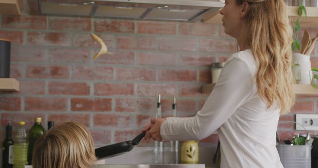 Mother Flipping Pancake in Kitchen with Child Watching - Download Free Stock Images Pikwizard.com