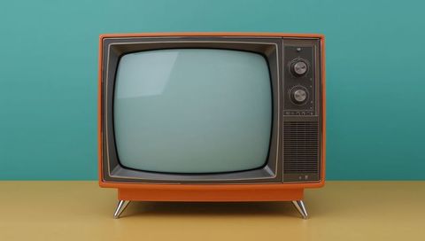 Retro orange television on yellow table