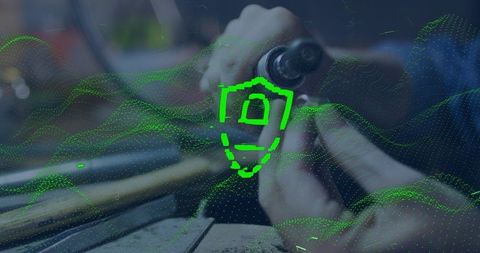 Crafting jewelry with rotary tool overlaid neon shield hologram representing cybersecurity