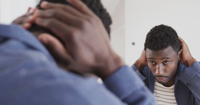 Young Man Reflecting in Mirror with Hands on Head - Download Free Stock Images Pikwizard.com