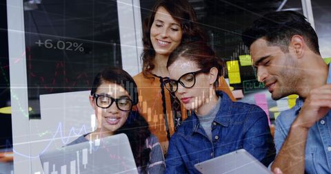 Diverse Colleagues Analyzing Financial Data on Digital Tools in Office