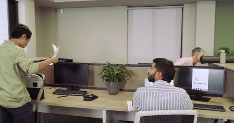 Modern office team collaboration with dual monitors