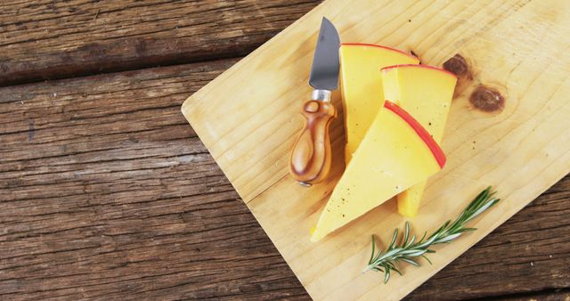 Sliced Gouda Cheese on Wooden Cutting Board with Knife and Rosemary - Download Free Stock Images Pikwizard.com