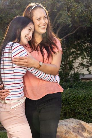 Mother and Daughter Embracing Outdoors in Backyard Scene