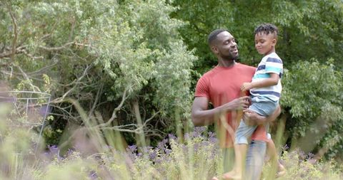 African American Father Enjoying Quality Time with Son in Lush Garden