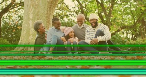 Multigenerational family laughing on autumn leaves with sweaters and green glitch lines