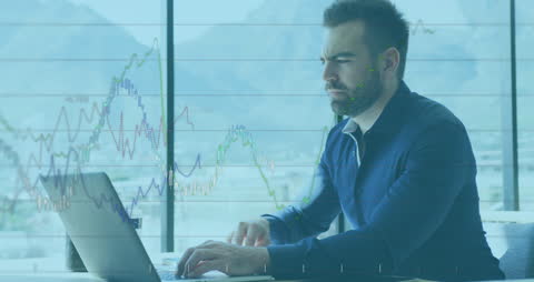 Focused Businessman Analyzing Financial Graphs on Laptop
