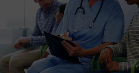 Nurse in blue scrubs taking notes in clinic waiting room