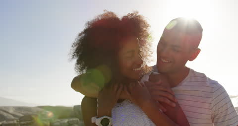 Happy Mixed-Race Couple Embracing on Sunny Beach