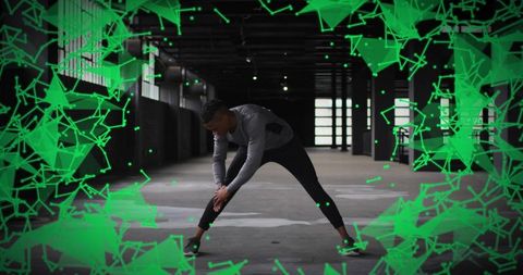 Man stretching in urban warehouse wearing leggings and shoes with neon geometric overlay