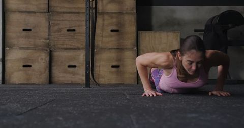 Fit Woman Executing Burpee in Industrial Gym Setting