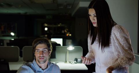 Colleagues Collaborating Late at Night in Modern Office
