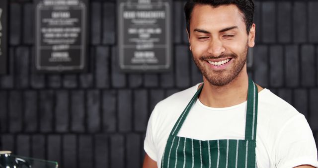 Smiling Male Barista Wearing Stripe Apron in Coffee Shop - Download Free Stock Images Pikwizard.com