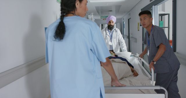 Healthcare professionals in uniforms transporting a patient on a hospital bed through a corridor. Ideal for use in healthcare, medical, emergency services, teamwork, and hospital support related content.