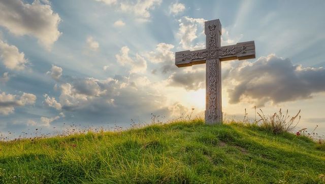Standing Carved Cross on Hilltop Meadow with Sun Ray Illumination