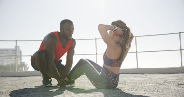 Personal Trainer Helping Woman with Sit-ups on Outdoor Terrace - Download Free Stock Images Pikwizard.com