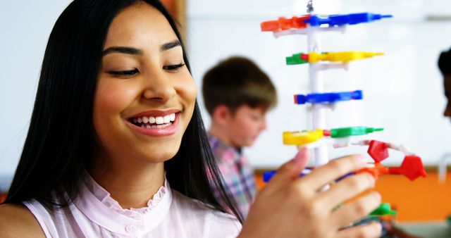 Happy girl engaging in science experiment with model in classroom - Download Free Stock Images Pikwizard.com