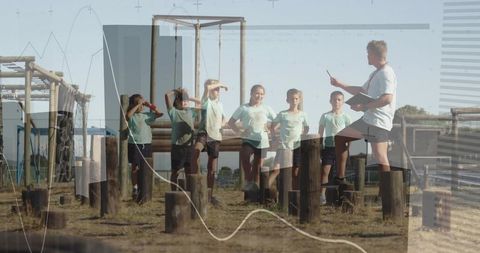 Group of Children Balancing on Obstacle Course with Coach Direction