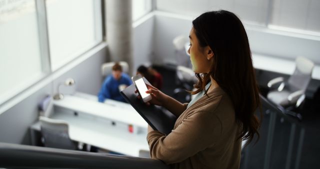 Businesswoman using smartphone in modern office setting - Download Free Stock Images Pikwizard.com