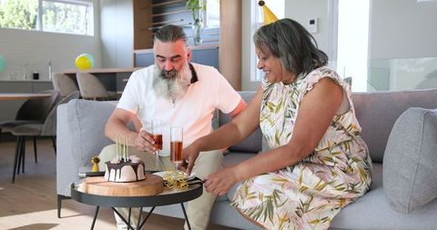 Senior Couple Celebrating Anniversary with Cake and Champagne at Home