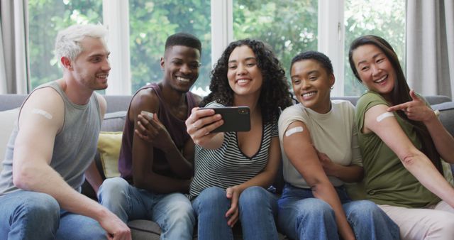 Diverse Friends Smiling While Showing Bandages and Taking a Selfie on Couch - Download Free Stock Images Pikwizard.com