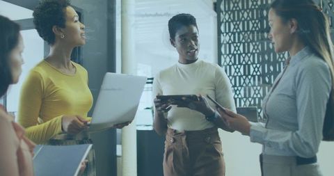 Midcareer professional leading team meeting with tablet and laptop in modern office