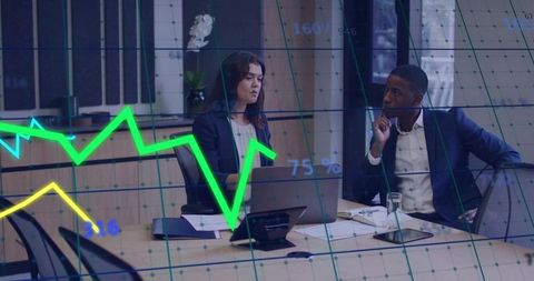 Reviewing financial data with interactive line graphs at corporate conference table