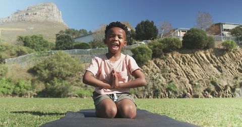Joyful Boy Practicing Yoga in Nature at Grass Field