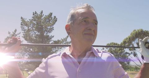 Senior Man Enjoying Golf on Sunny Day with Light Streaks