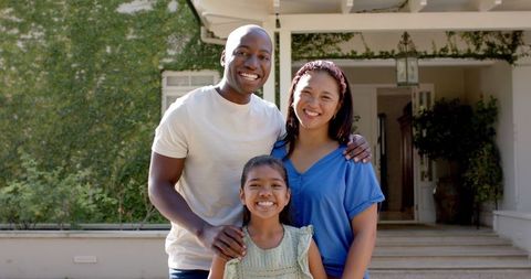 Family of three enjoying quality time outside home smiling
