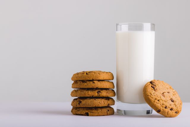 Milk glass with stack of cookies against white background, copy space. unaltered, food, drink, studio shot and healthy eating.